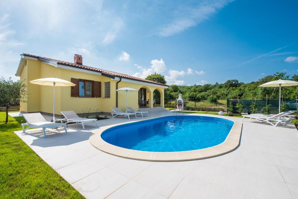 een villa met een zwembad en een huis bij Villa Carmela in Labin