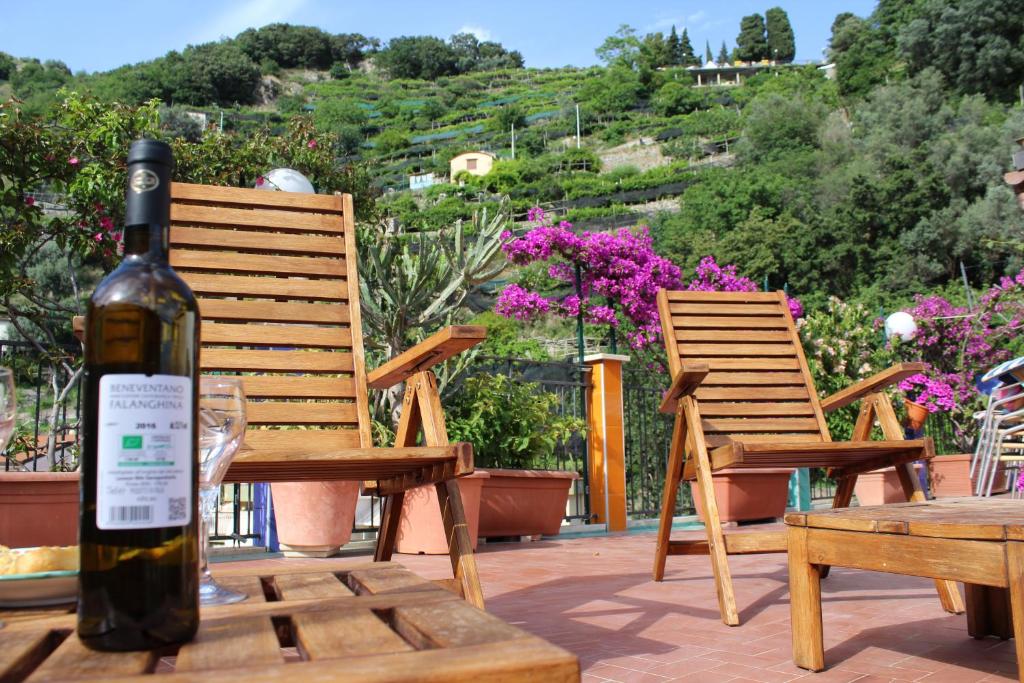 a bottle of wine sitting on a table with two chairs at Reginella in Cetara