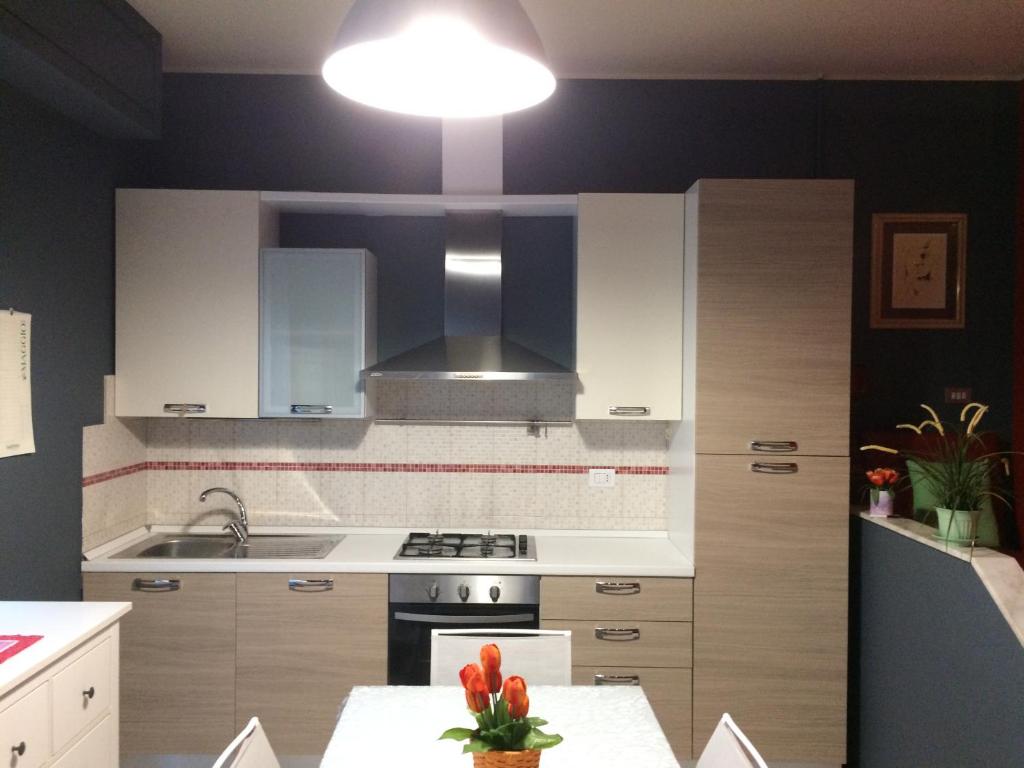 cocina con armarios blancos, fregadero y luz en Affittacamere LA PISANA en Porto SantʼElpidio