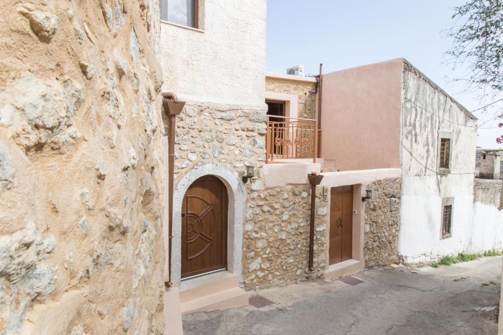 ein Gebäude mit einer Tür und einer Steinmauer in der Unterkunft Nivritos Traditional Homes in Nívritos