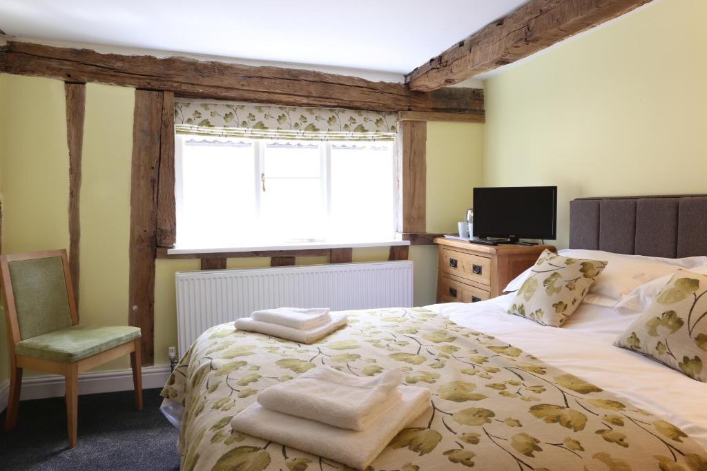 - une chambre avec un grand lit et une fenêtre dans l'établissement The Kings Head, à New Buckenham