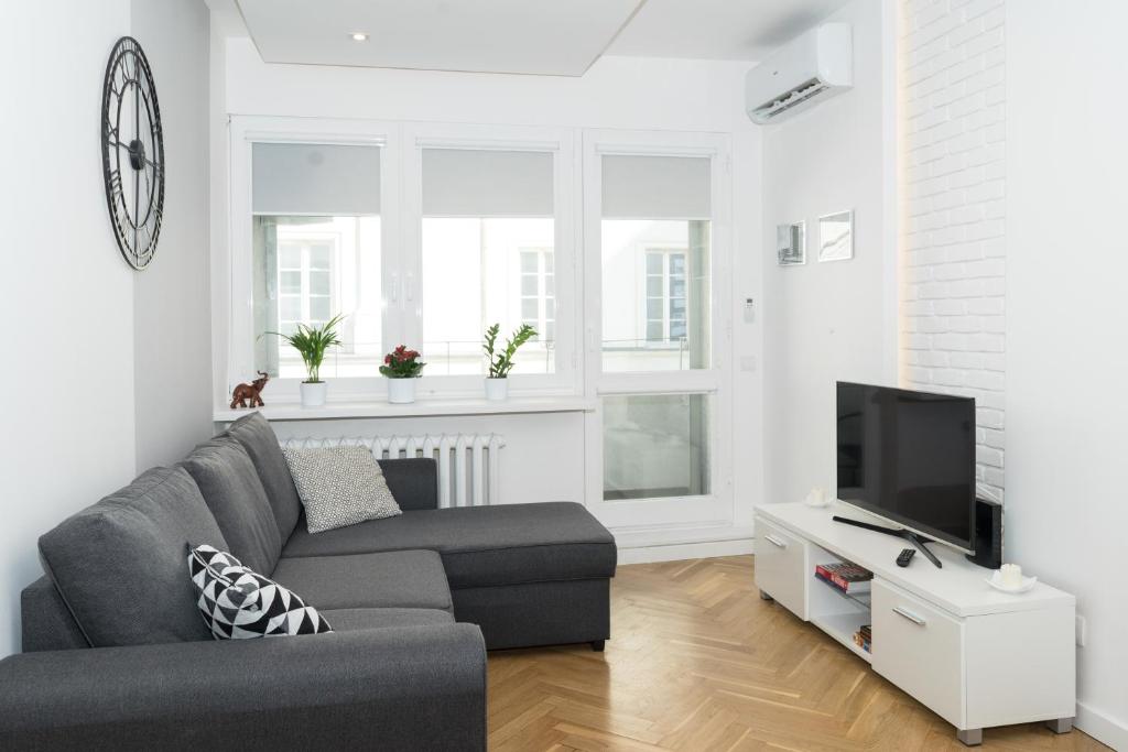 a living room with a couch and a tv at Old Town Grand Theatre Apartment 2 in Warsaw