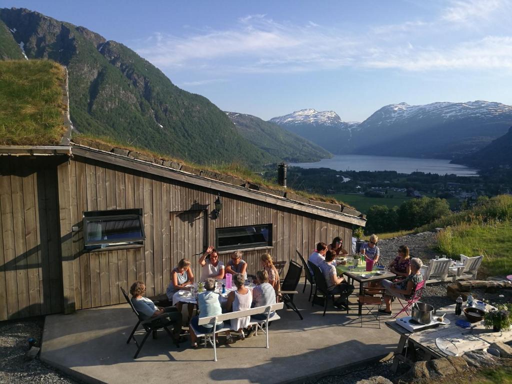 eine Gruppe von Personen, die auf einer Terrasse auf Stühlen sitzen in der Unterkunft Ein heilt spesiell låve i Røldal in Røldal