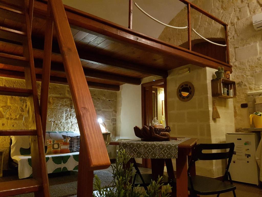a kitchen with a table and a spiral staircase at Guesthouse A Casina b&b in Trani