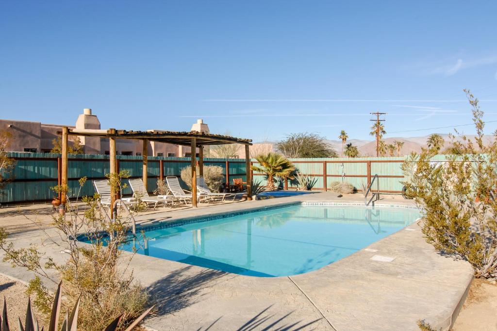 a swimming pool with chairs and a gazebo at Borrego Valley Inn in Borrego Springs
