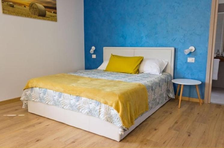a bedroom with a bed with a yellow pillow and a table at Il Gatto Stanco B&B in Arona