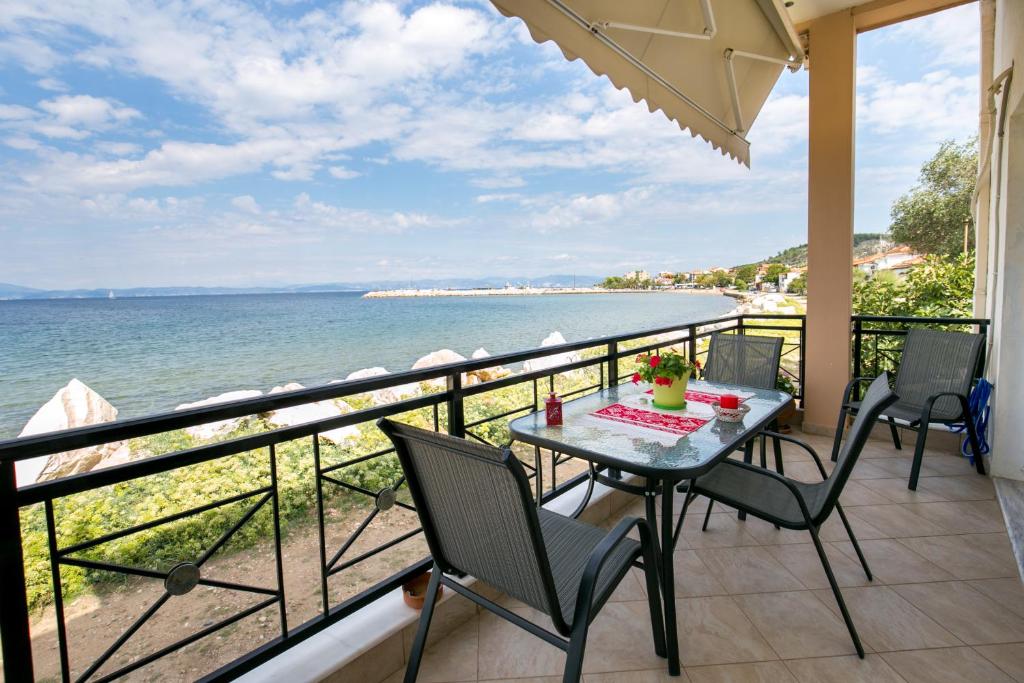 a balcony with a table and chairs and the ocean at Kallisti Apartment in Skala Kallirachis