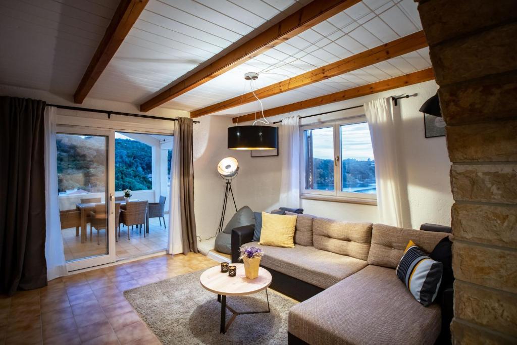 una sala de estar con un sofá y una mesa en Beach Suite Nina, en Rab