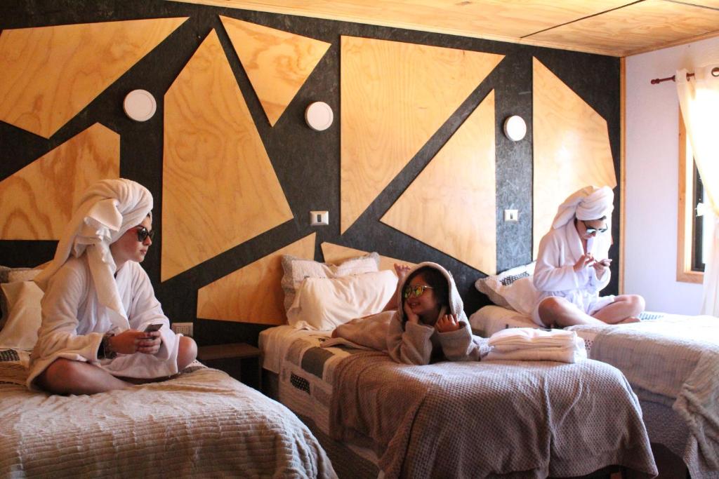 a group of people sitting on beds in a room at Residencial del Maule in Linares