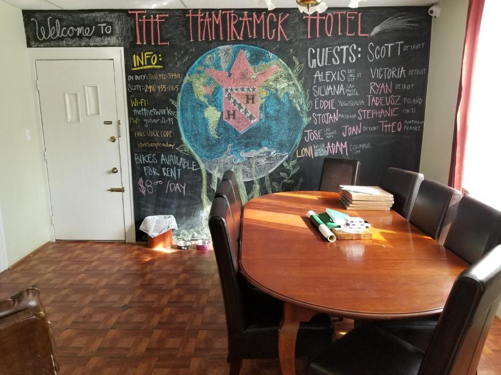 a table in a restaurant with a chalkboard on the wall at Hamtramck Hostel in Detroit