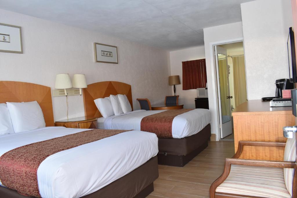 una habitación de hotel con 2 camas y una silla en Blue Water Motel, en Wildwood Crest