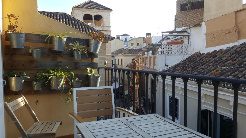 un balcón con sillas y macetas en un edificio en APT GUADALHORCE by Malaga Picasso Rentals Selection, en Málaga