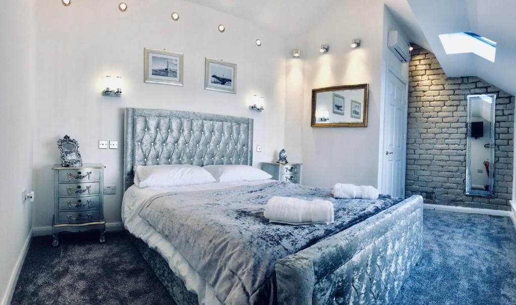 1 dormitorio con 1 cama grande y pared de ladrillo en Luxury Apartment, en Blackpool