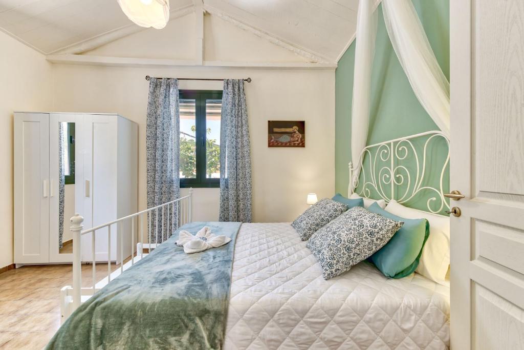 ヴァシリコスにあるVilla Canellaのベッドルーム1室(青と緑のシーツが備わるベッド1台付)