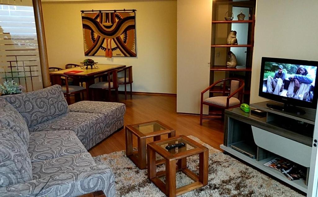 sala de estar con sofá y TV en Conforto, praticidade e seguranca!, en Curitiba