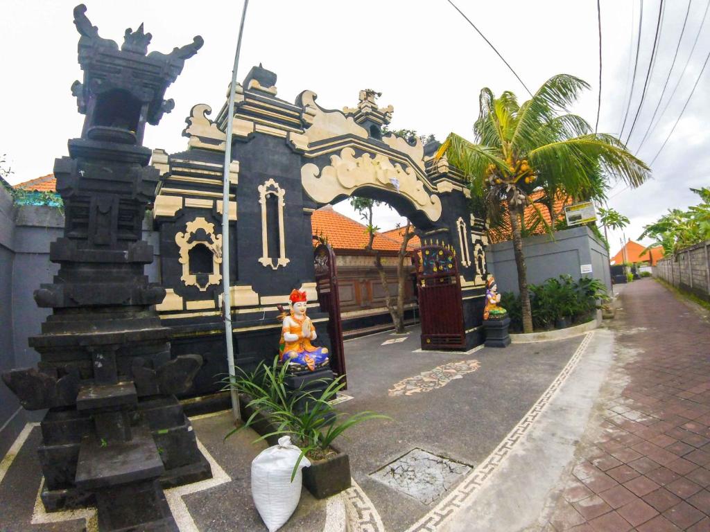 a building with a gate in front of a street at Putu Guest House in Canggu