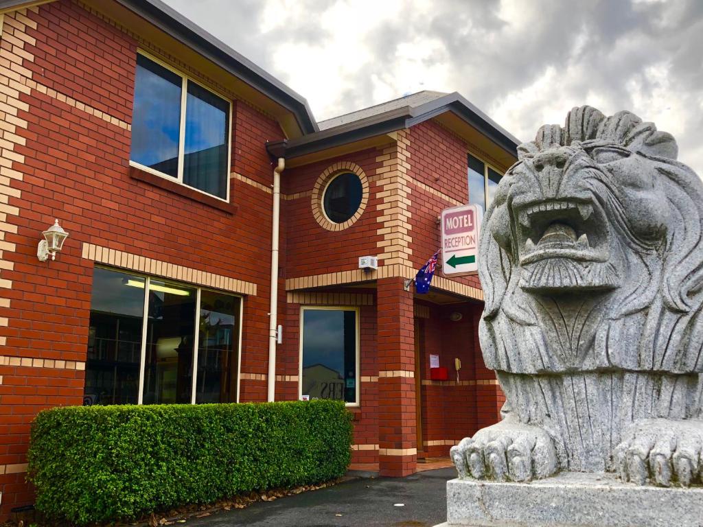 una estatua de un león frente a un edificio de ladrillo en Sheffield Motor Inn, en Sheffield