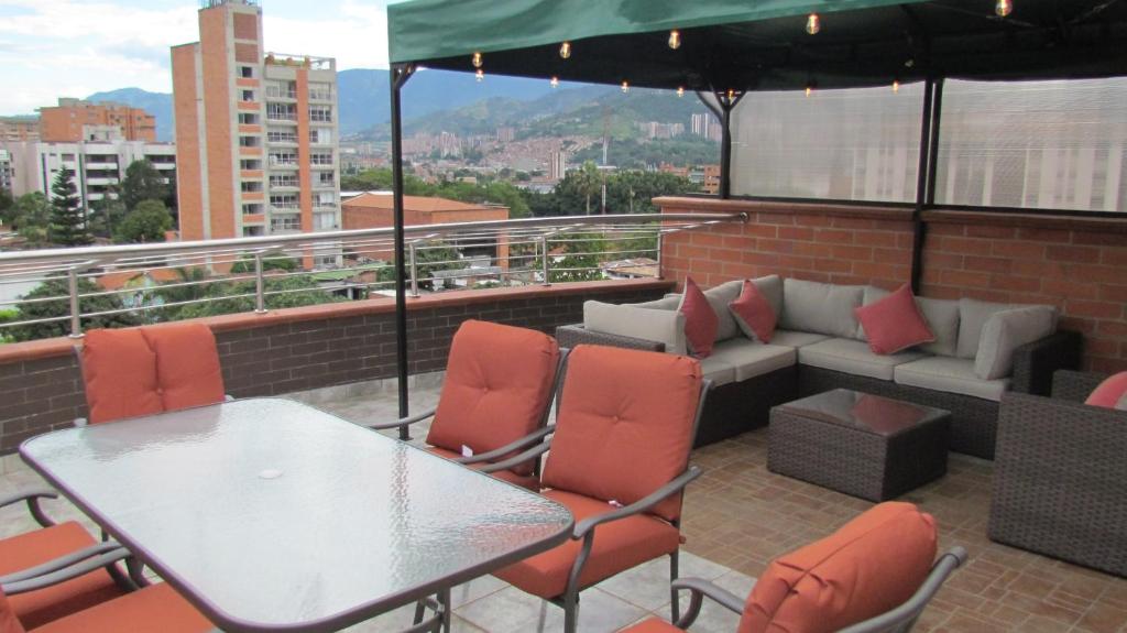 un patio con mesa, sillas y sofá en The 9's Apartahotel, en Medellín