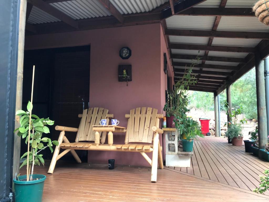 two chairs and a table on a porch at Thistle Do Bed and Breakfast in Bridgetown