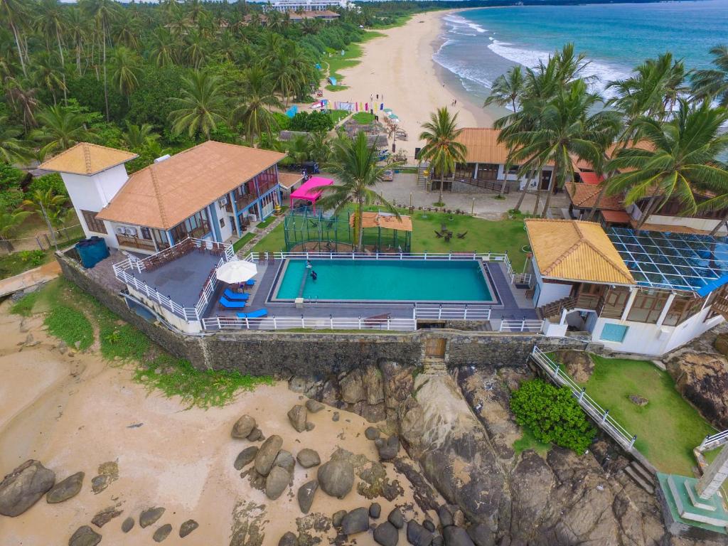 an aerial view of a house with a swimming pool and a beach at White VIlla Resort in Ahungalla