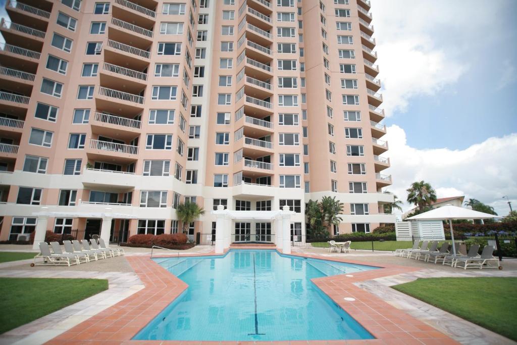 a swimming pool in front of a large apartment building at Belle Maison Apartments - Official in Gold Coast