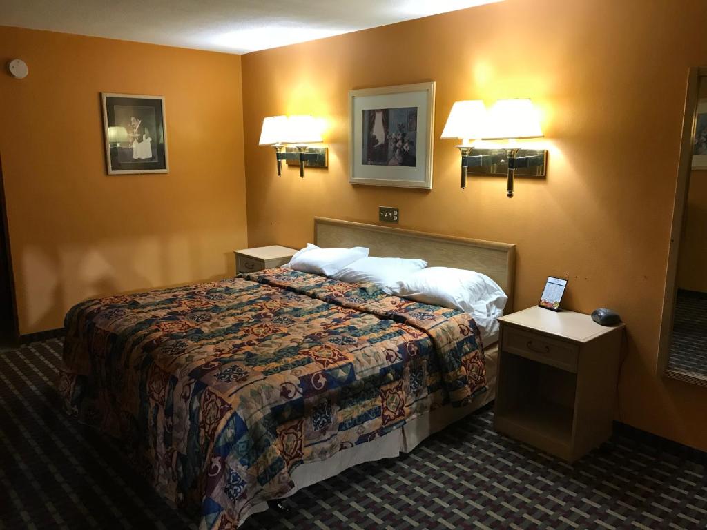 a hotel room with a bed and two lights on the wall at Spring Valley Inn in Spring Valley