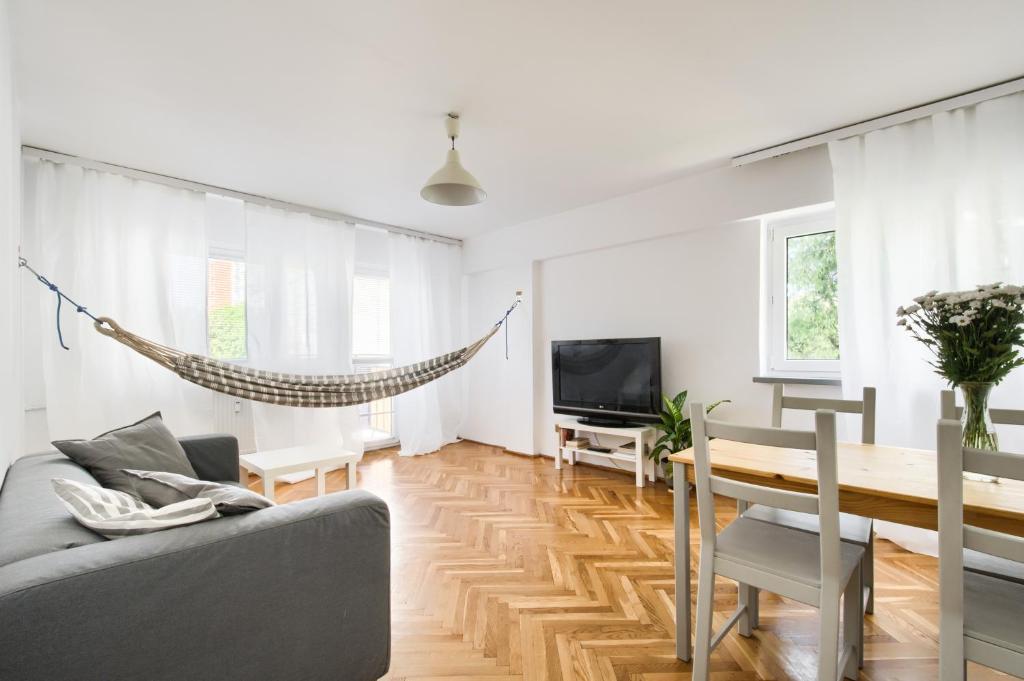 un soggiorno con divano e tavolo di Chmielna Hammock Apartment a Varsavia