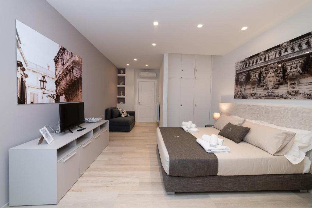1 dormitorio con 1 cama y TV en Taranta Suite en Lecce