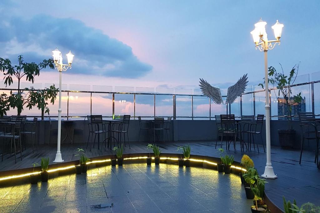 eine Dachterrasse mit einem Pool, Tischen und Stühlen in der Unterkunft ASTON Lampung City Hotel in Bandar Lampung