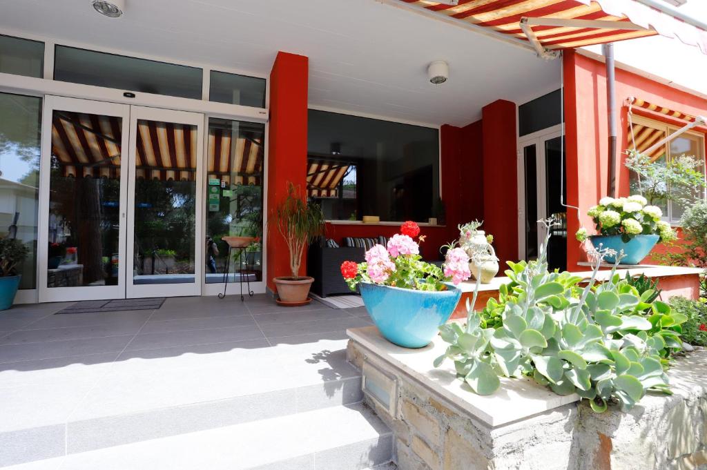 a patio with potted plants in front of a building at Hotel Grifone in Principina a Mare