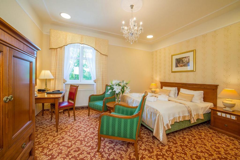 a bedroom with a bed and a table and chairs at Spa Resort PAWLIK-AQUAFORUM in Františkovy Lázně