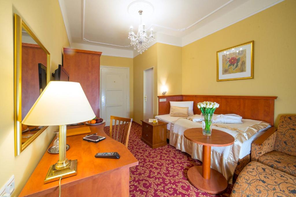 a hotel room with a bed and a table with a lamp at Spa Resort PAWLIK-AQUAFORUM in Františkovy Lázně