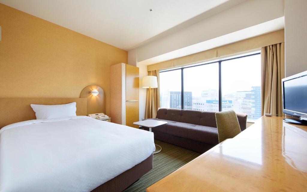 a hotel room with a bed and a couch at Shin Yokohama Prince Hotel in Yokohama