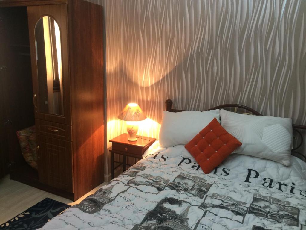 a bedroom with a bed and a table with a lamp at Location appartement Oran Akid lotfi in Oran