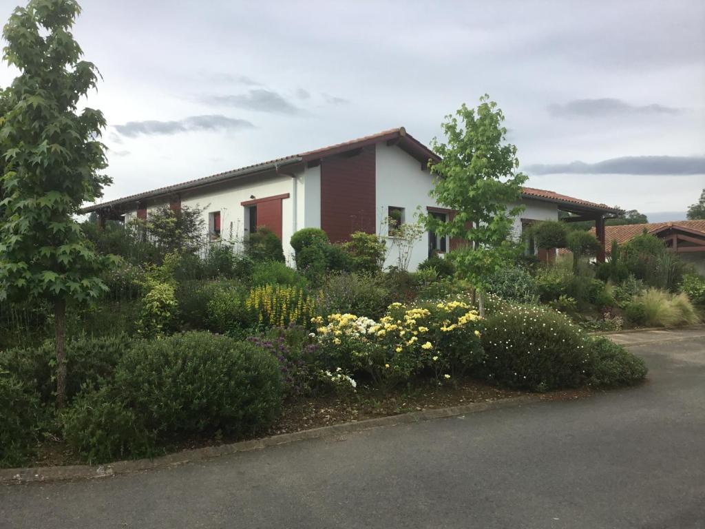 una casa con muchas flores delante de ella en Maison Fleurie en Uhart-Cize