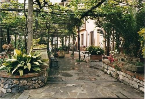 a garden with a walkway with plants and trees at Locanda Dal Moccia in La Spezia