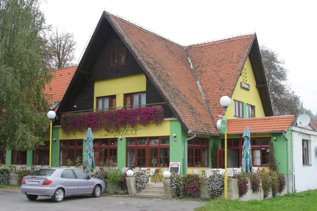 un bâtiment avec une voiture garée devant lui dans l'établissement Guest House Prepelica, à Prelog