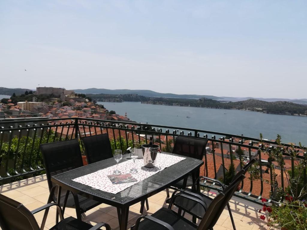 a table on a balcony with a view of the water at Apartman Betty in Šibenik