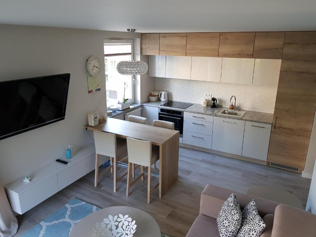 eine Küche und ein Wohnzimmer mit einem Tisch und Stühlen in der Unterkunft Apartamentdziwnówek in Dziwnówek