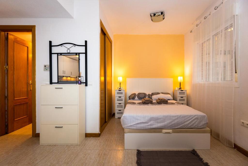 ベニドルムにあるHola Apartment Benidormのベッドルーム1室(鏡付きベッド1台、ドレッサー付)