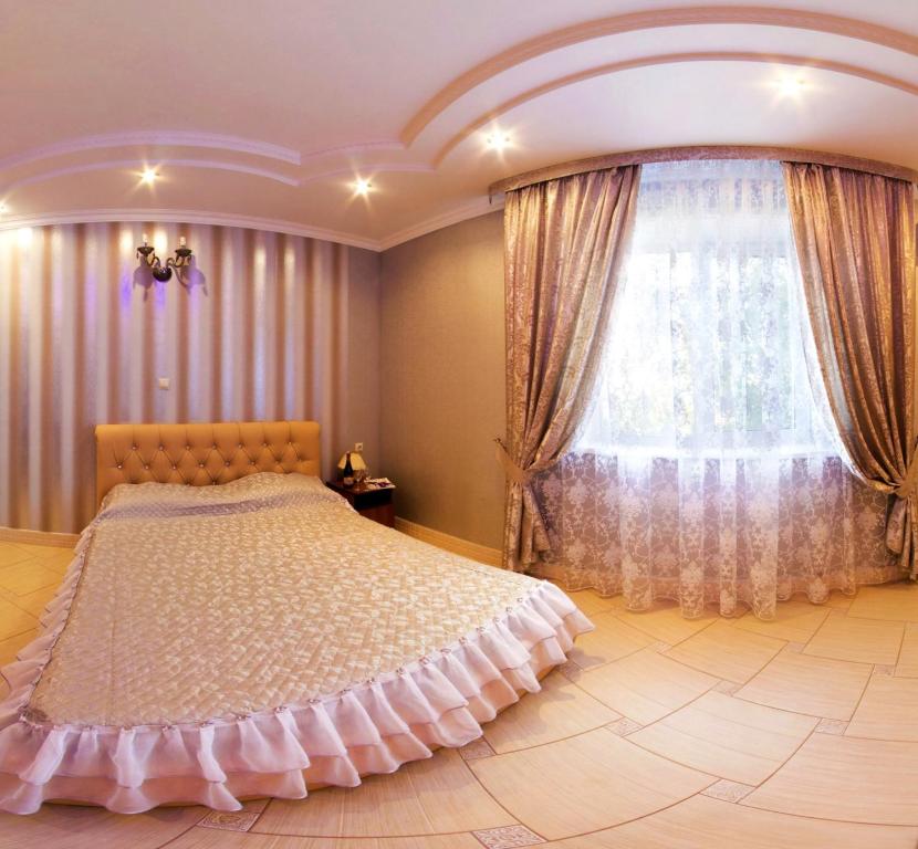 a bedroom with a large bed and a window at Alladin Hotel in Orenburg