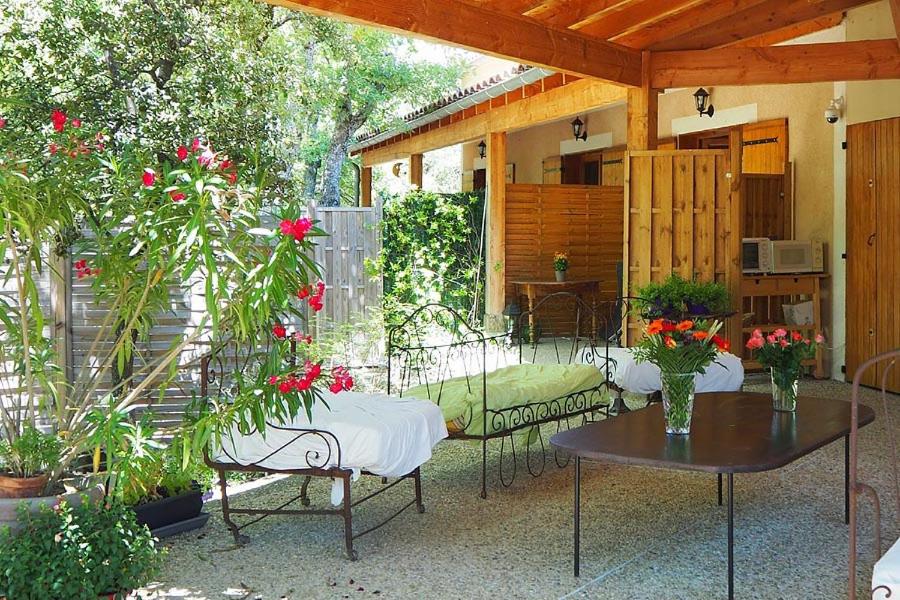 - une terrasse avec 2 tables, des chaises et des fleurs dans l'établissement Escapades en Ventoux, à Venasque