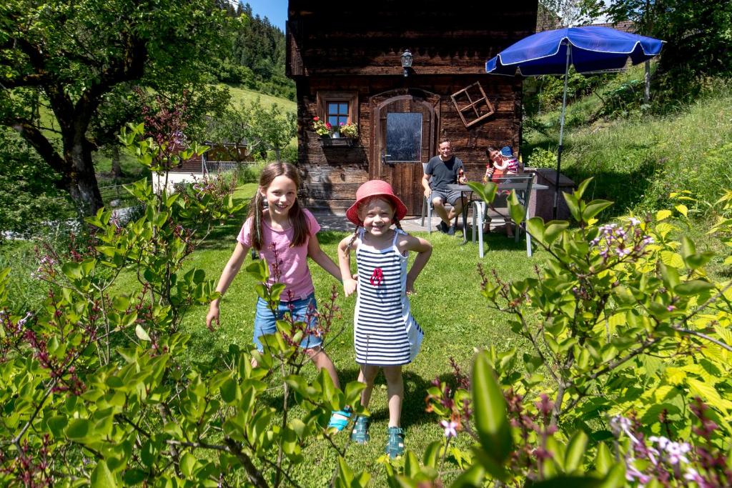 two little girls are walking in the yard at Chalet "Knusperhäuschen" in Murau