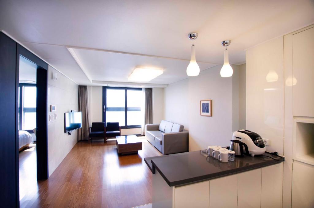 uma ampla sala de estar com uma cozinha e uma sala de estar em Plea De Blanc Hotel & Residence em Busan