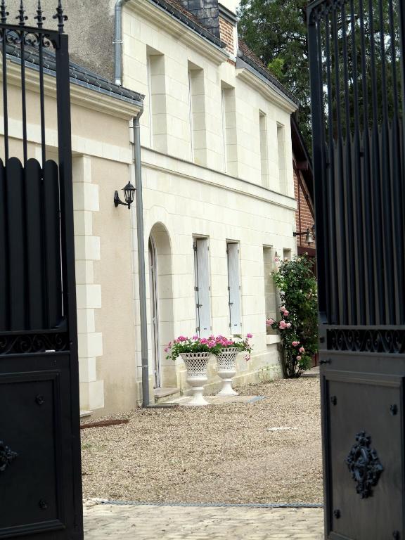 - l'entrée d'un bâtiment avec un portail et des fleurs dans l'établissement Le Clos Richelieu, à Amboise