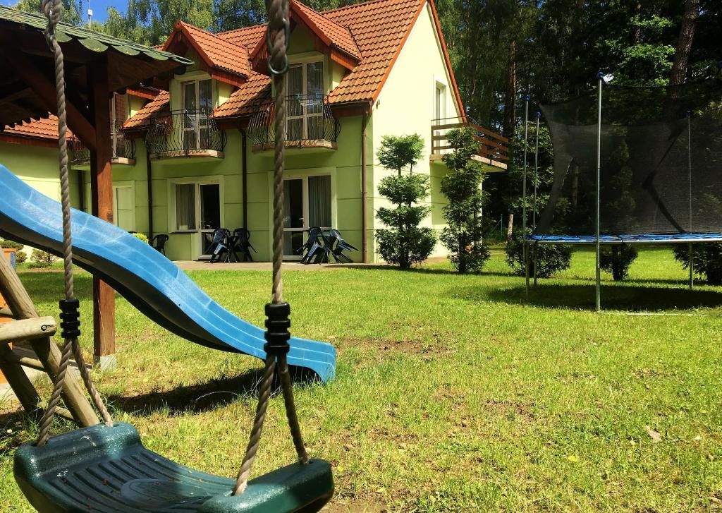a playground with a slide in front of a house at Wachta Pobierowo in Pobierowo