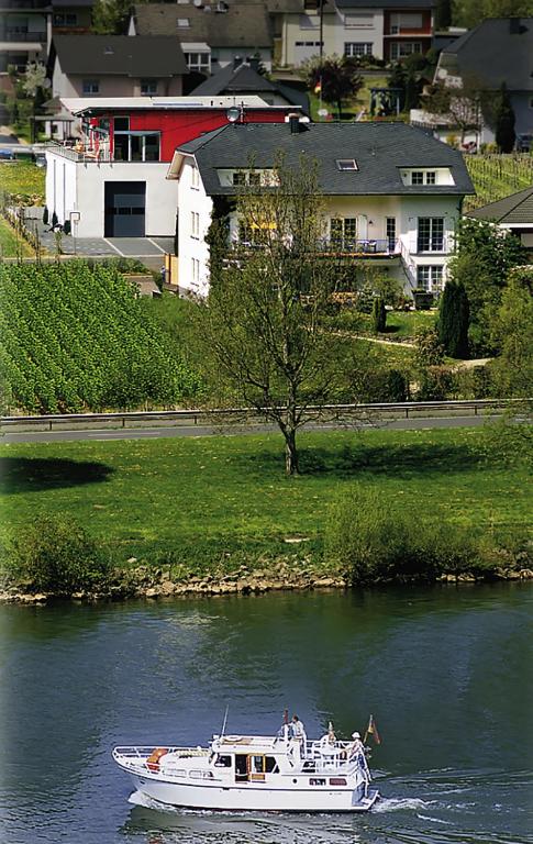 a white boat on the water in a river at Weingut Bernd Hermes in Kröv
