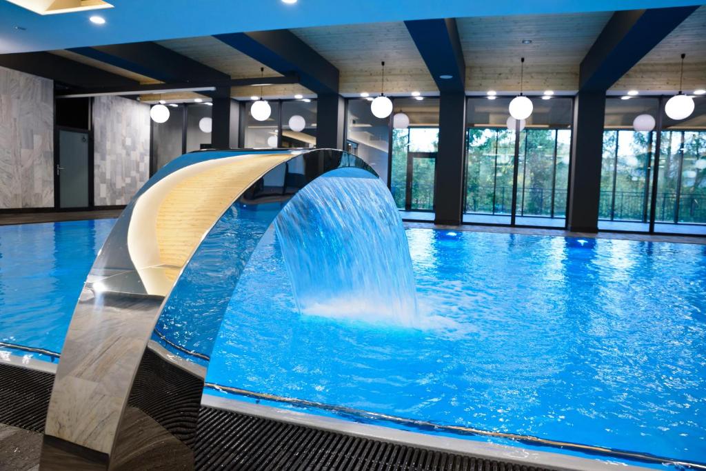 a swimming pool with a water slide at Hotel SPA Budowlani in Szczawnica