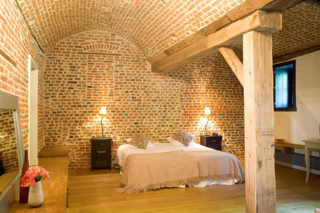 a brick walled bedroom with a bed in a room at Hotel The Lodge Heverlee in Leuven