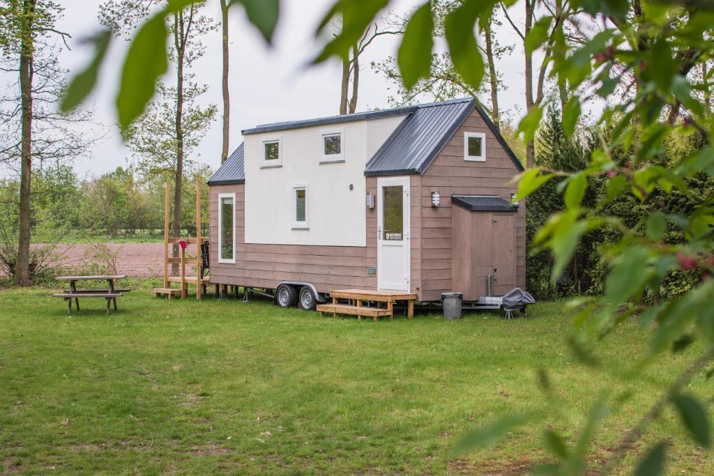 a tiny house on a trailer in a yard at Tiny House in Ootmarsum